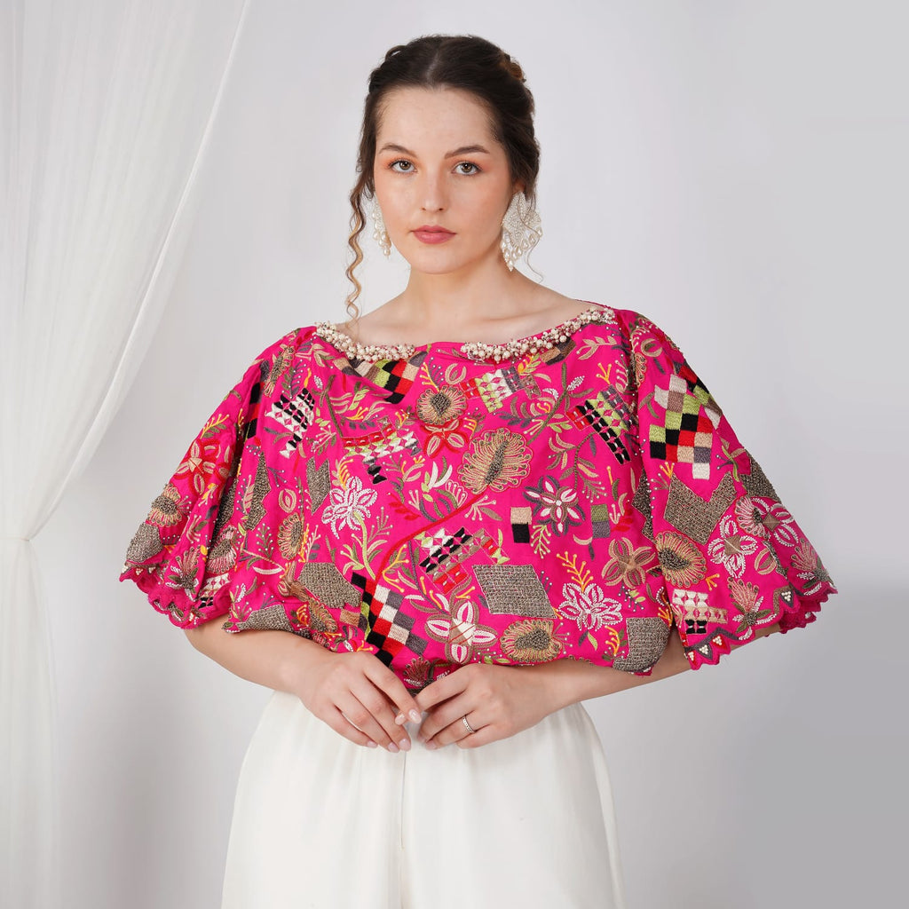 Close-up of pink silk cape with pearl and Zardosi embroidery
